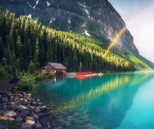Rainbow Shines over Lake at Cabin Near Mountain